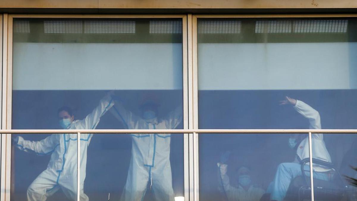 Sanitarios del Hospital del Mar bromean con la gente en el paseo marítimo de Barcelona durante el segundo día que las personas adultas pueden salir a la calle a pasear.