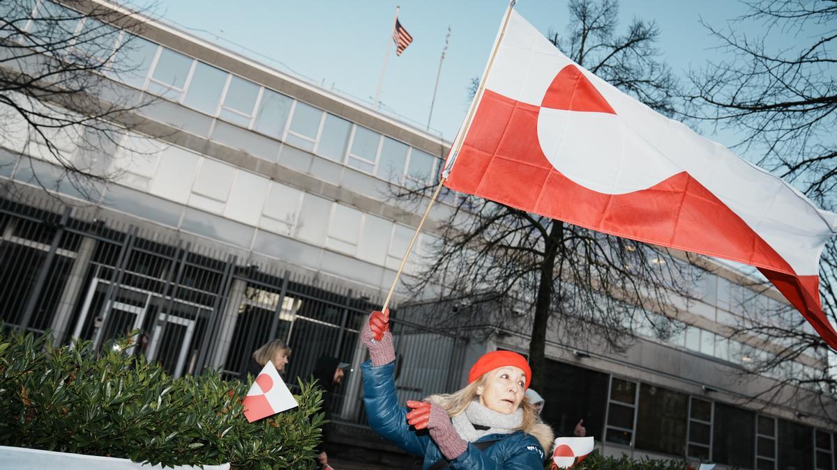 Manifestante ondea la bandera de Groenlandia en frente de la embajada de Estados Unidos en Copenhague.