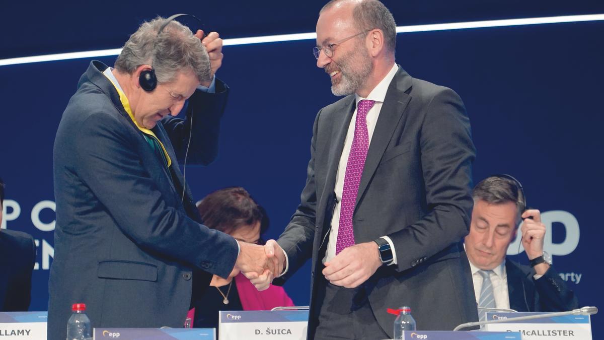 Feijóo, liándose con los cascos, saluda a Manfred Weber, presidente del PPE, en Valencia durante su último Congreso el pasado mes de abril.