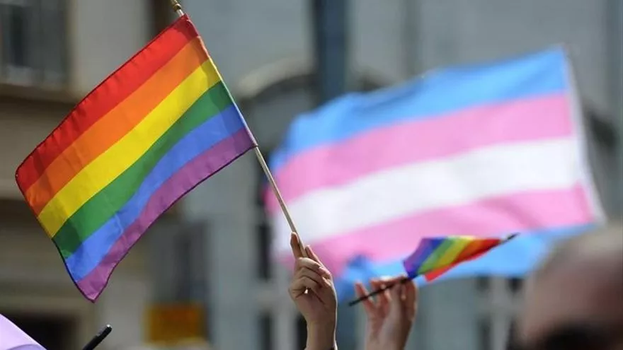 Imagen de la bandera LGTBI y la bandera trans.