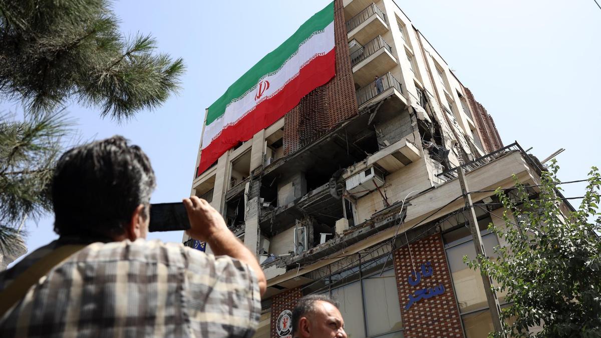 Iranies observan los daños a un edificio en Teherán.