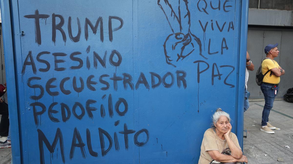 Una mujer descansa frente a un mural durante una marcha del chavismo este martes, en Caracas (Venezuela).