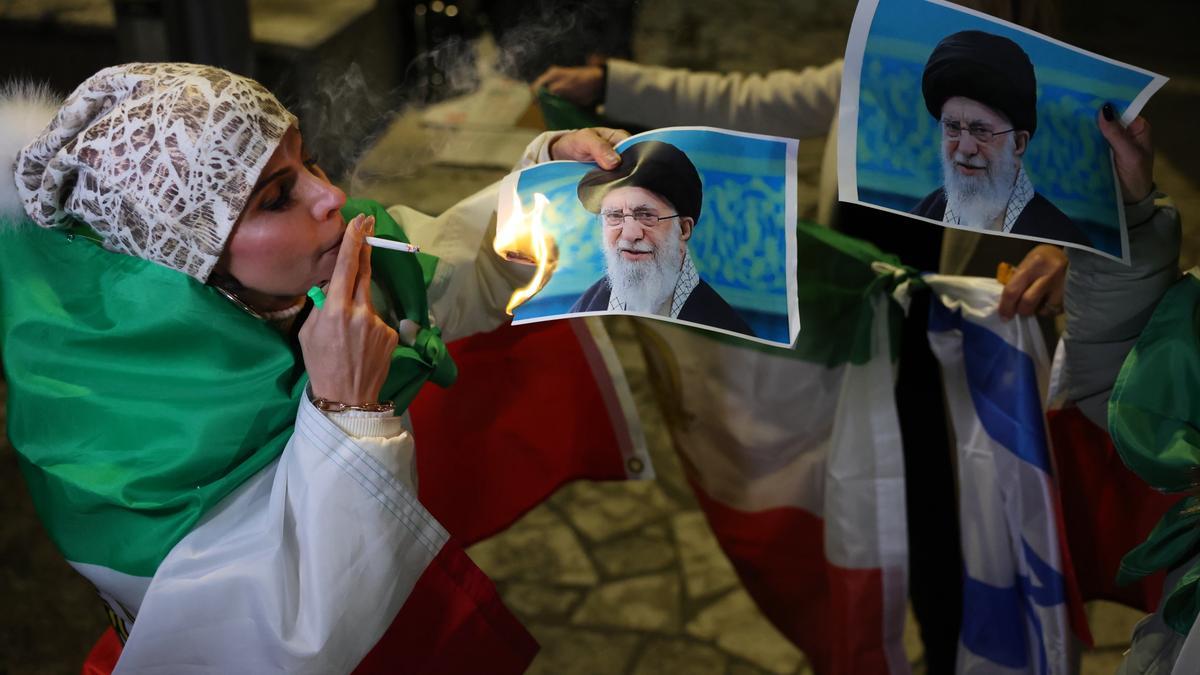 Una integrante de la comunidad iraní israelí quema una foto del líder supremo de Irán, Ali Khamenei.