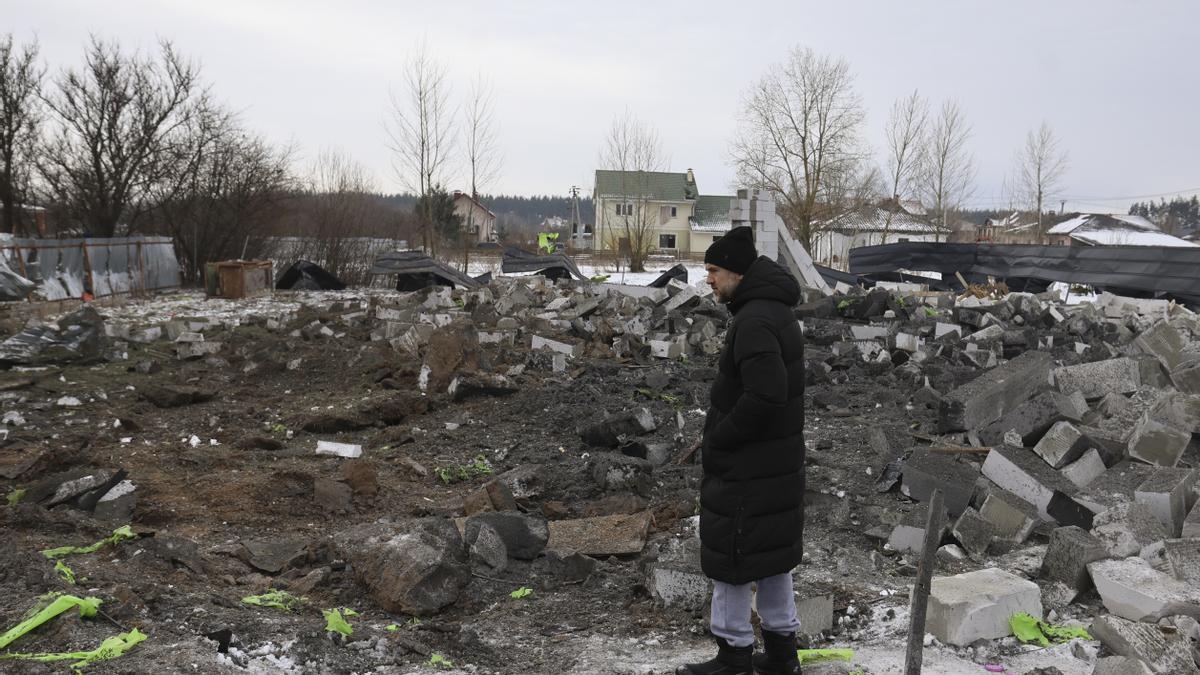 La gente inspecciona los daños en el lugar de un ataque ruso cerca de un edificio residencial en Putrivka, región de Kiev, Ucrania, el 22 de febrero de 2026