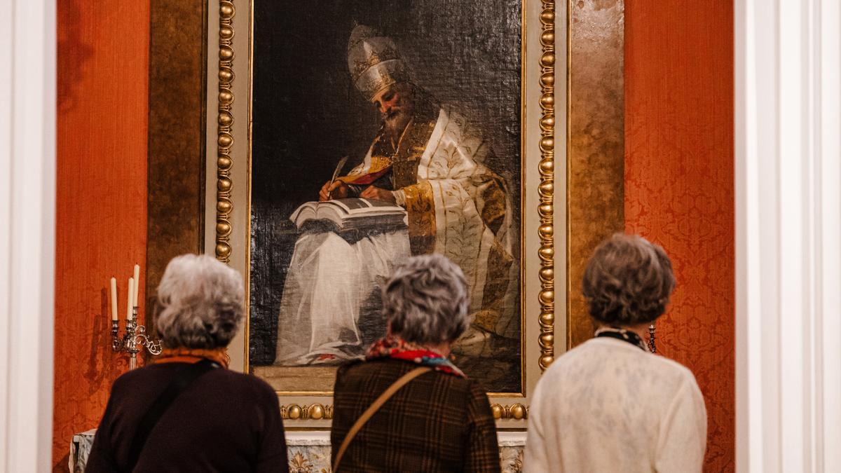 Tres personas observan una de las obras expuestas en el Museo del Romanticismo.