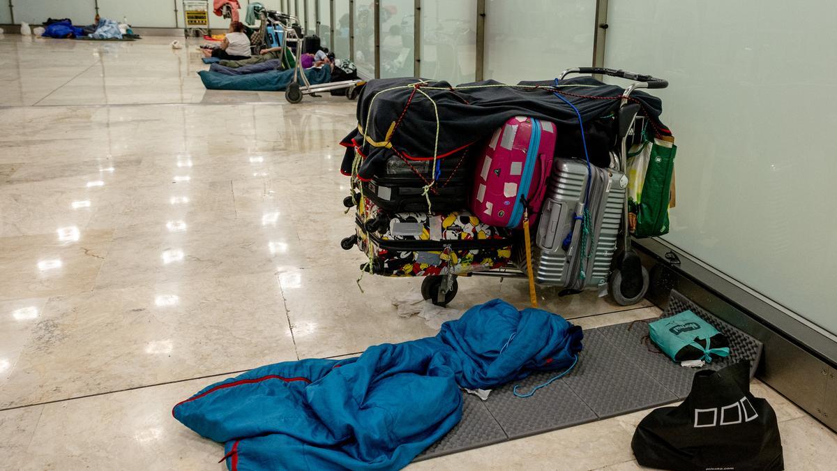 Personas durmiendo en el aeropuerto de Barajas la noche en la que Aena ha comenzado los controles de acceso.