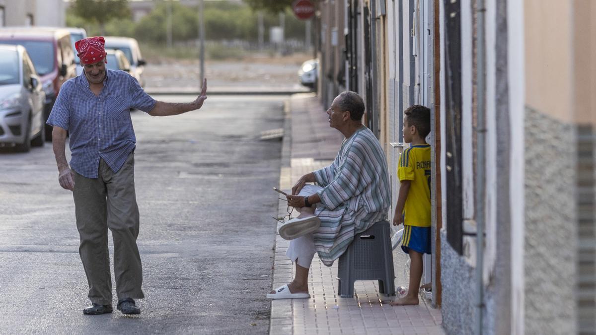 Vecinos marroquís toman el fresco en la puerta de su casa del barrio de San Antonio de Torre Pacheco.