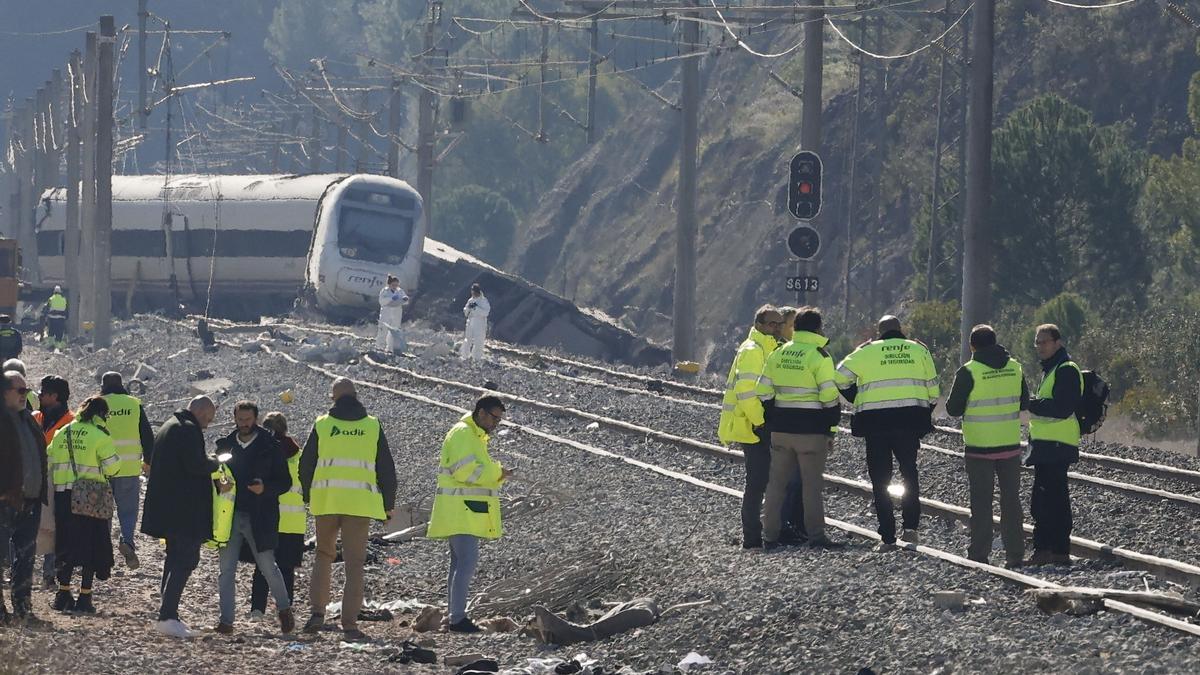 Varias personas trabajan junto a los vagones siniestrados del accidente ferroviario en Adamuz (Córdoba).