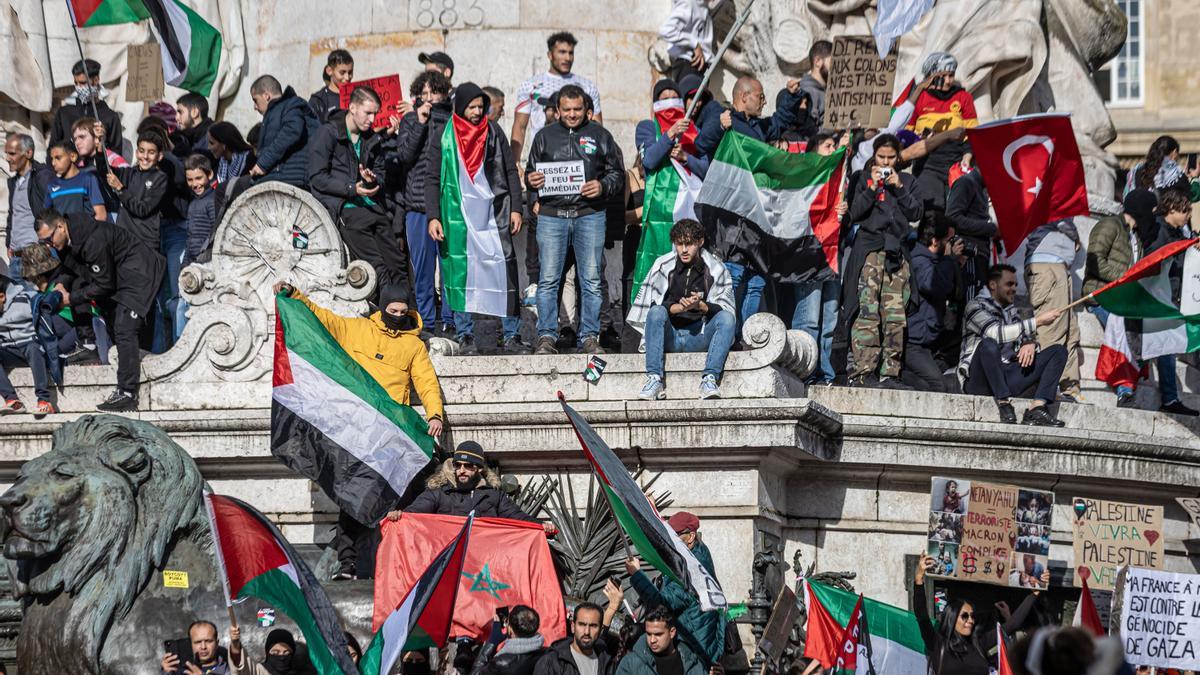 Manifestantes sostienen banderas palestinas durante una manifestación de apoyo a Palestina, en la Plaza de la República de París, Francia.