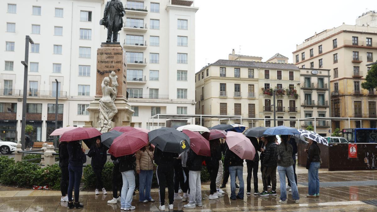 Un grupo de personas se protege de la lluvia con paraguas.