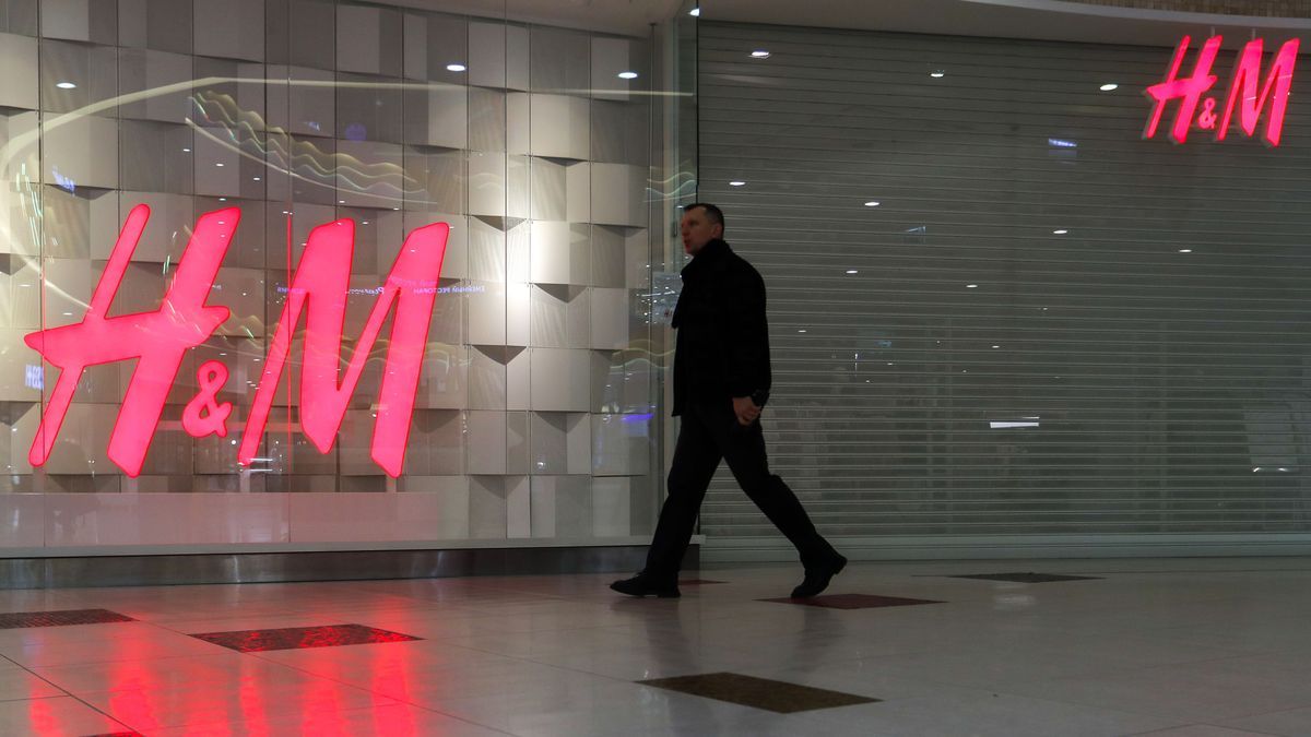 Un hombre pasa frente a una tienda cerrada de H&M.