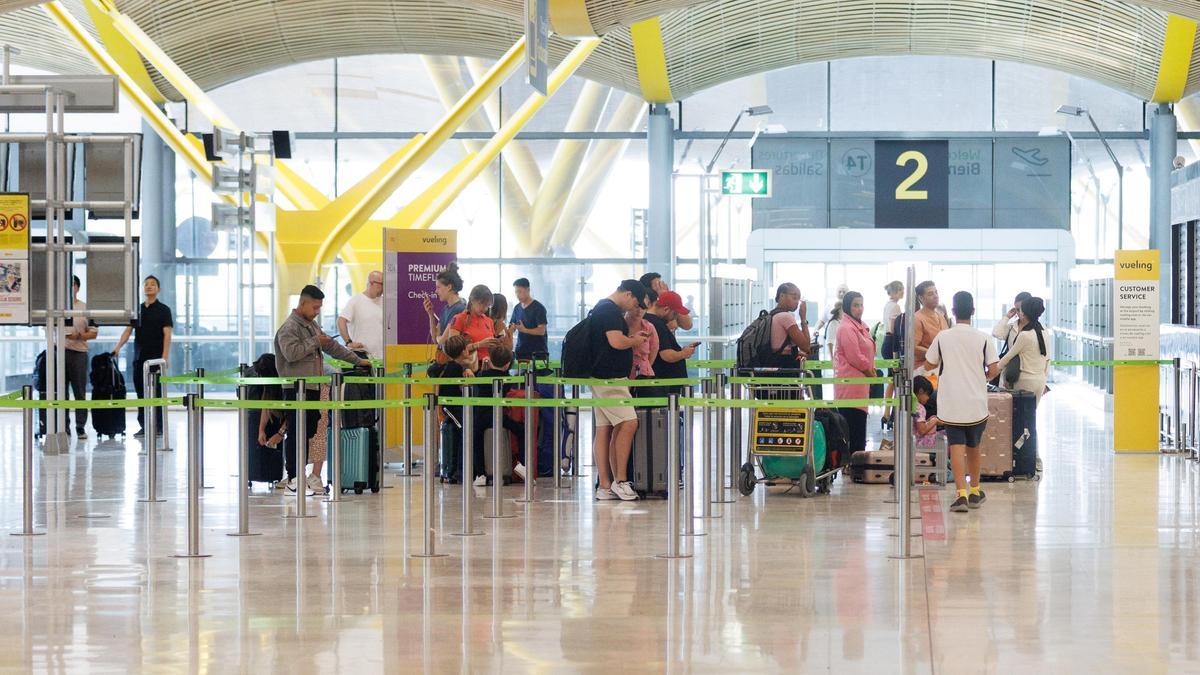 Un grupo de personas esperan al acceso del control de la Terminal T4 del Aeropuerto Adolfo Suárez-Madrid Barajas con motivo de la operación salida de inicios de agosto, a 28 de julio de 2023, en Madrid (España).La red de aeropuertos de Aena prev