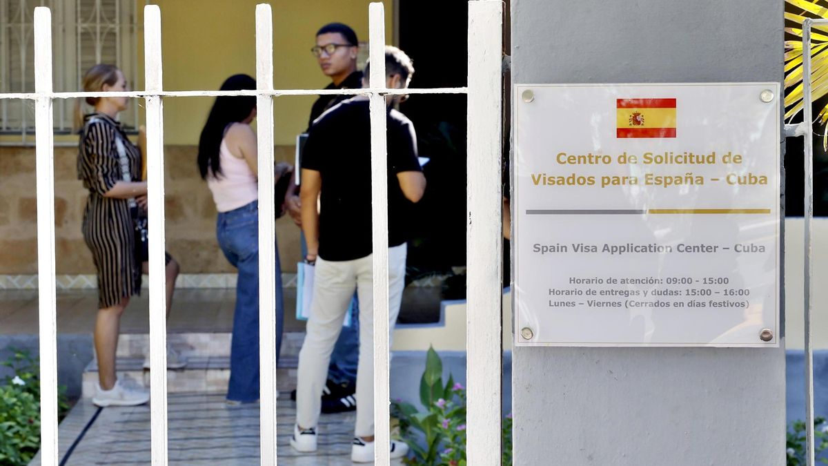 Varias personas hacen cola a la puerta de una oficina consular española en La Habana (Cuba).