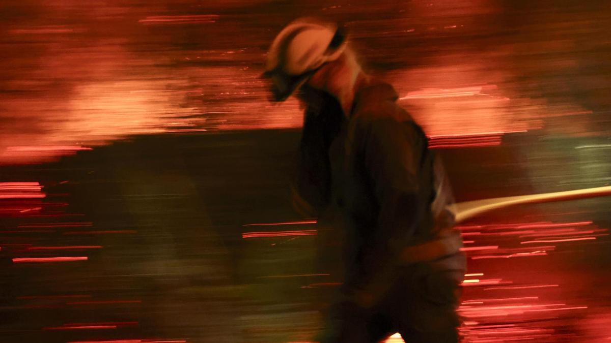 Bomberos forestales antes las grandes llamas del incendio en Aguasmestas, una parroquia del municipio de Quiroga.