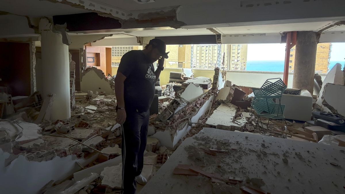 Una persona habla por teléfono en una edificación destruida por los terremotos del 24 de junio en Catia La Mar (Venezuela).