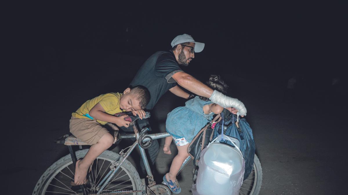 Imagen de un hombre con dos niños en Gaza.
