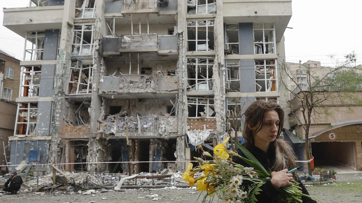 Una mujer pasa por delante de un edificio residencial alcanzado por un dron ruso en Kiev, Ucrania.