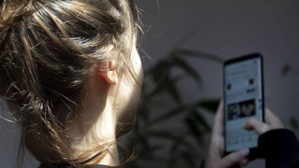 Una adolescente consulta su teléfono móvil