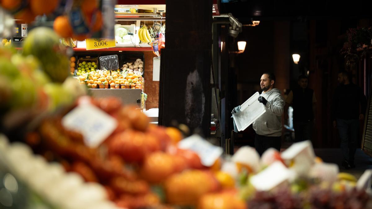 Un comerciante revisa sus productos expuestos, en el Mercado de la Boquería, a 14 de diciembre de 2023.