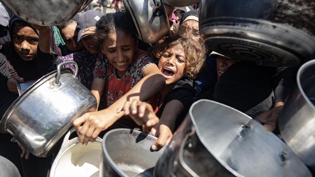 Palestinos hacen cola para recibir comida en Khan Yunis, en el sur de la Franja de Gaza.