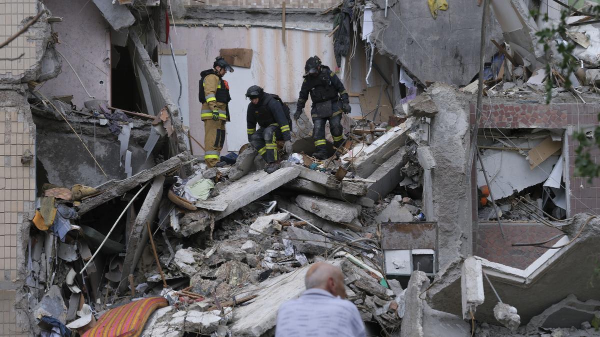 Los rescatistas ucranianos y los servicios municipales buscan supervivientes bajo los escombros tras el ataque a un edificio residencial destruido el 7 de mayo de 2025.