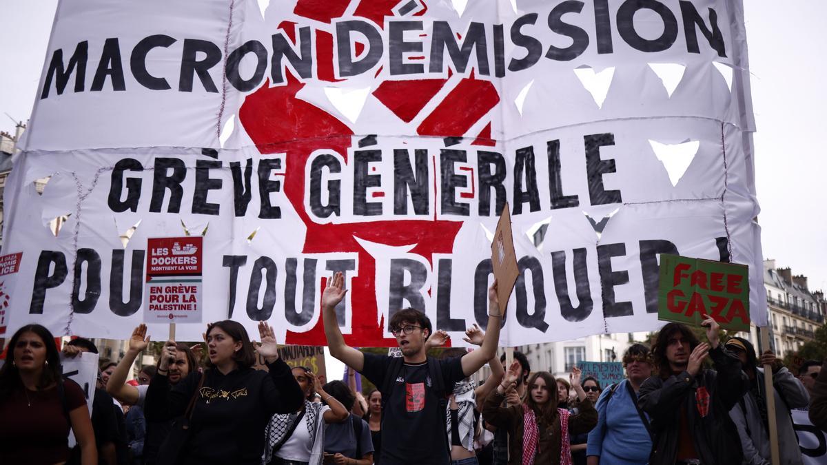 Manifestantes portan una pancarta en la que se lee "¡Macron, dimisión, huelga general!" durante las protestas en París el 2 de octubre de 2025.