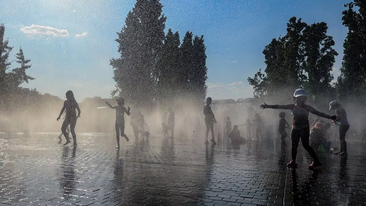 Varios niños se refrescan en una fuente durante la tercera ola de calor en Madrid, en el parque Madrid Río, a 3 de agosto.