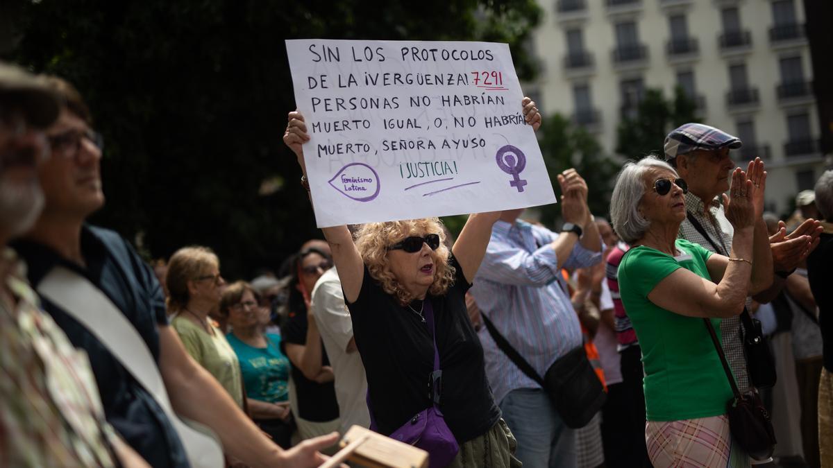 Varias personas durante un homenaje a los fallecidos en las residencias de mayores durante la pandemia de covid en la Comunidad de Madrid.