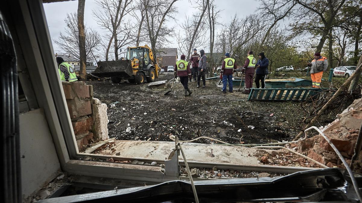 Trabajadores municipales ucranianos trabajan en el lugar donde se produjo un ataque aéreo ruso contra un edificio privado en Járkov, al noreste de Ucrania, el 21 de octubre de 2025, en medio de la invasión rusa.