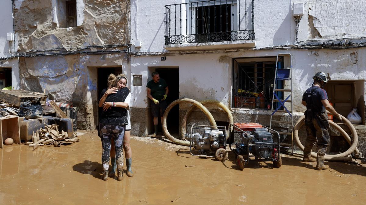 Vecinos de la localidad zaragozana de Letux achican barro y retiras mobiliario dañado este domingo.