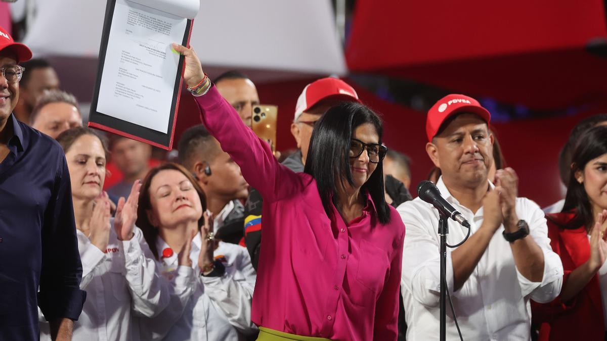 La presidenta encargada de Venezuela, Delcy Rodríguez (c), muestra un documento este jueves, en Caracas (Venezuela).