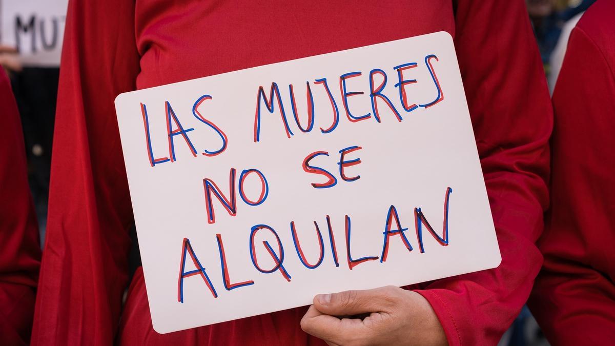 Una mujer con una pancarta que reza 'Las Mujeres no se Alquilan' se manifiesta bajo el lema ‘Las mujeres no se alquilan, los bebés no se compran’, frente al Ministerio de Justicia.