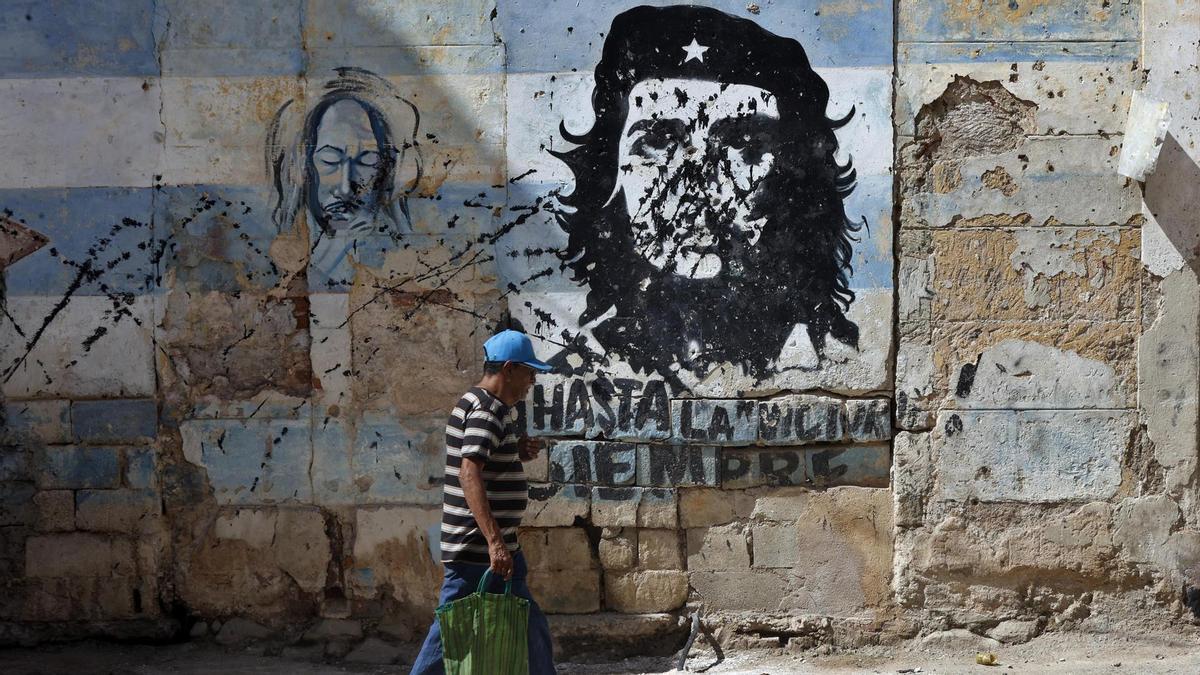 Una persona camina frente a un mural con la imagen de Ernesto 'Che' Guevara en una calle de La Habana, Cuba.
