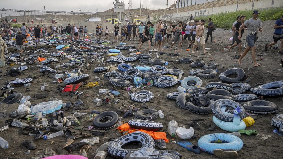 Flotadores y migrantes tras traspasar la frontera entre Ceuta y Marruecos, a 31 de julio de 2026.