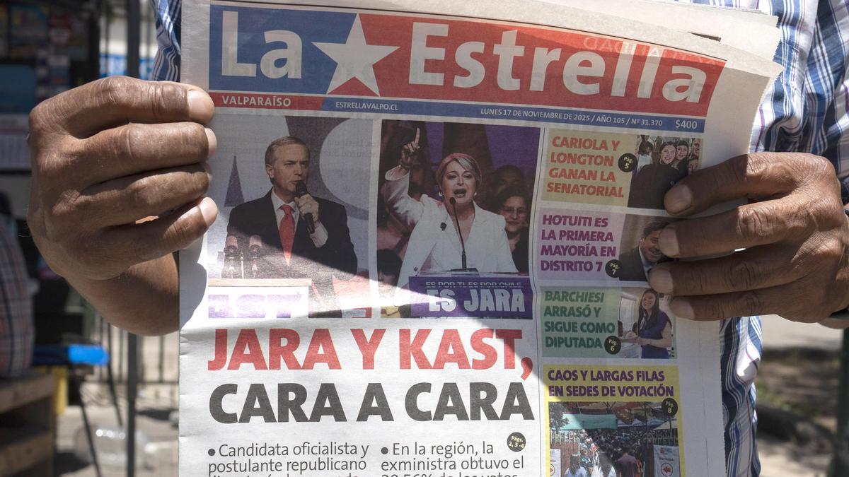 Un hombre sostiene un periódico en Chile que muestra a la comunista y candidata del oficialismo chileno Jeannette Jara y al ultraderechista José Antonio Kast