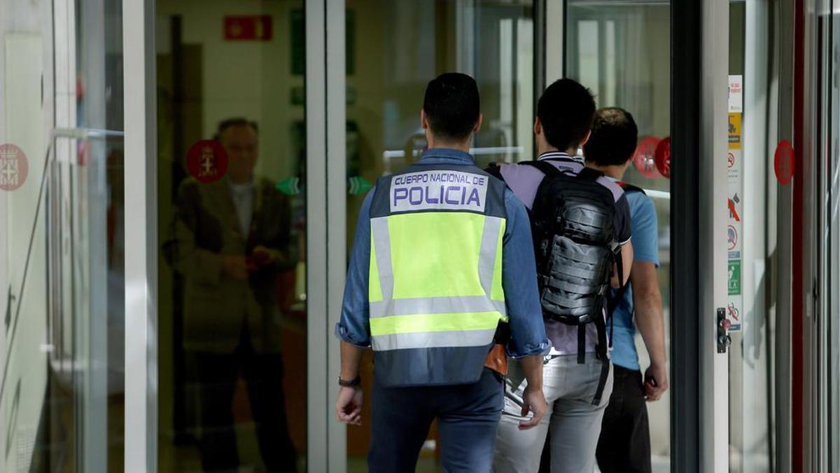 Varios policías se dirigen hacia la entrada de la sede de la Diputación de Barcelona en la calle Londres.