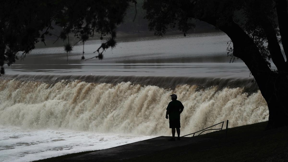 Personas observan el río Guadalupe fluir sobre una presa, donde el río alcanzó los 10,5 metros de altura en su cresta el 4 de julio, en Kerrville, Texas.