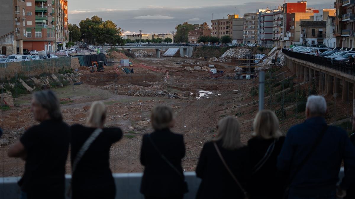 Varias personas hacen una cadena humana para homenajear a las víctimas de la dana, en la Rambla del Poyo, a 26 de octubre de 2025, en Paiporta, Valencia.