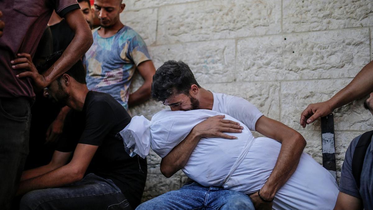 Un padre palestino llora el cuerpo de su hija en el hospital Al Aqsa en Deir al Balah antes del entierro.