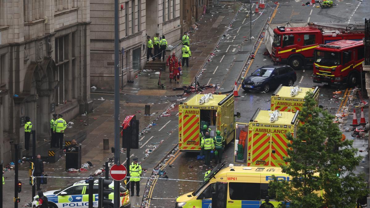 Integrantes de la policía custodian una calle donde un automóvil chocó con aficionados de Liverpool durante el desfile del trofeo este lunes, en la ciudad de Liverpool (Reino Unido).