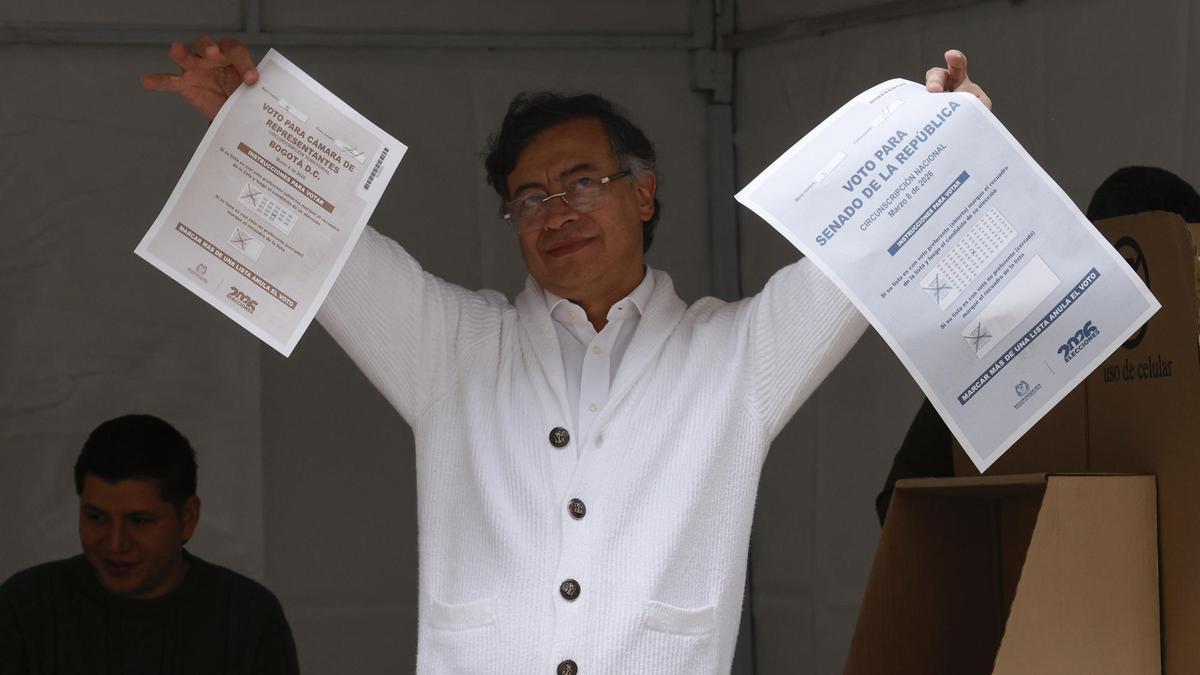 El presidente de Colombia, Gustavo Petro, muestra las papeletas para Senado y Cámara antes de votar este domingo, en Bogotá.