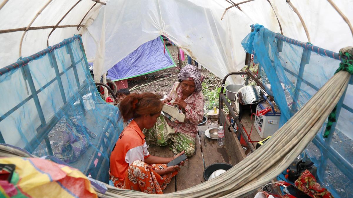 Mujeres sentadas en un campamento improvisado para civiles desplazados por los enfrentamientos en la disputada frontera entre Tailandia y Camboya, en la provincia de Oddar Meanchey, al noroeste de Camboya.