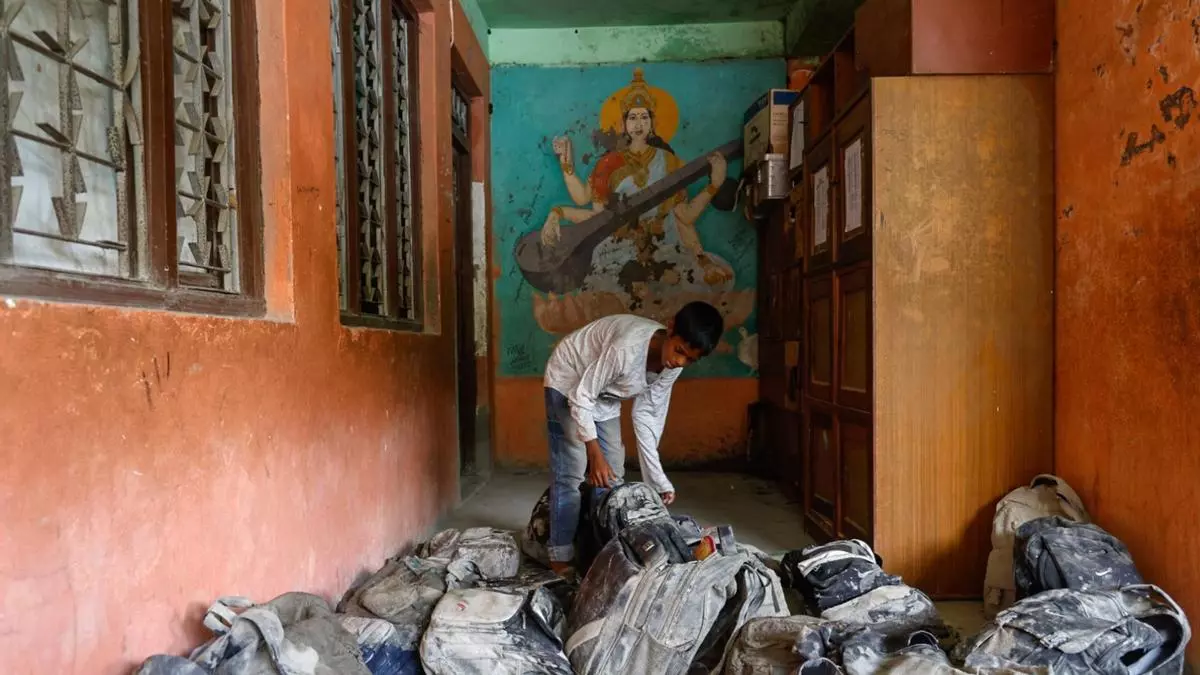 Un estudiante busca su mochila en la escuela secundaria Bageshwori, dañada por la colosal riada, en el distrito de Dhading (Nepal).