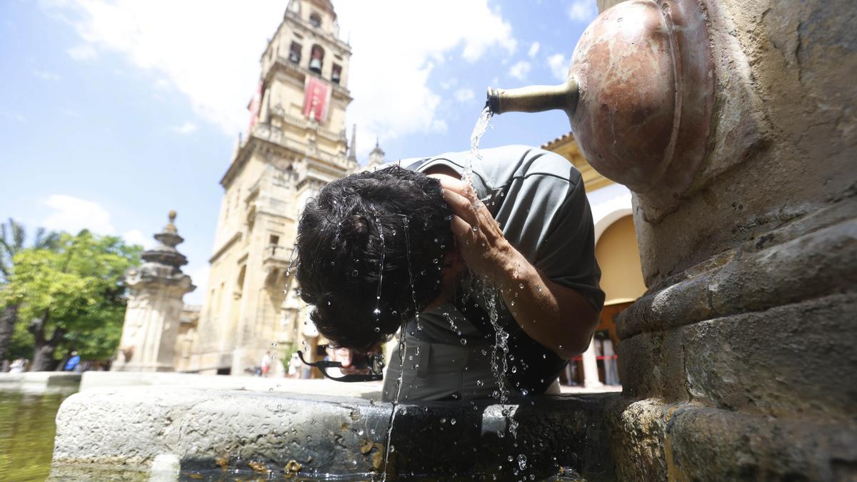 Un turista se refresca en una fuente del Patio de los Naranjos de la Mezquita Catedral de Córdoba, este martes.