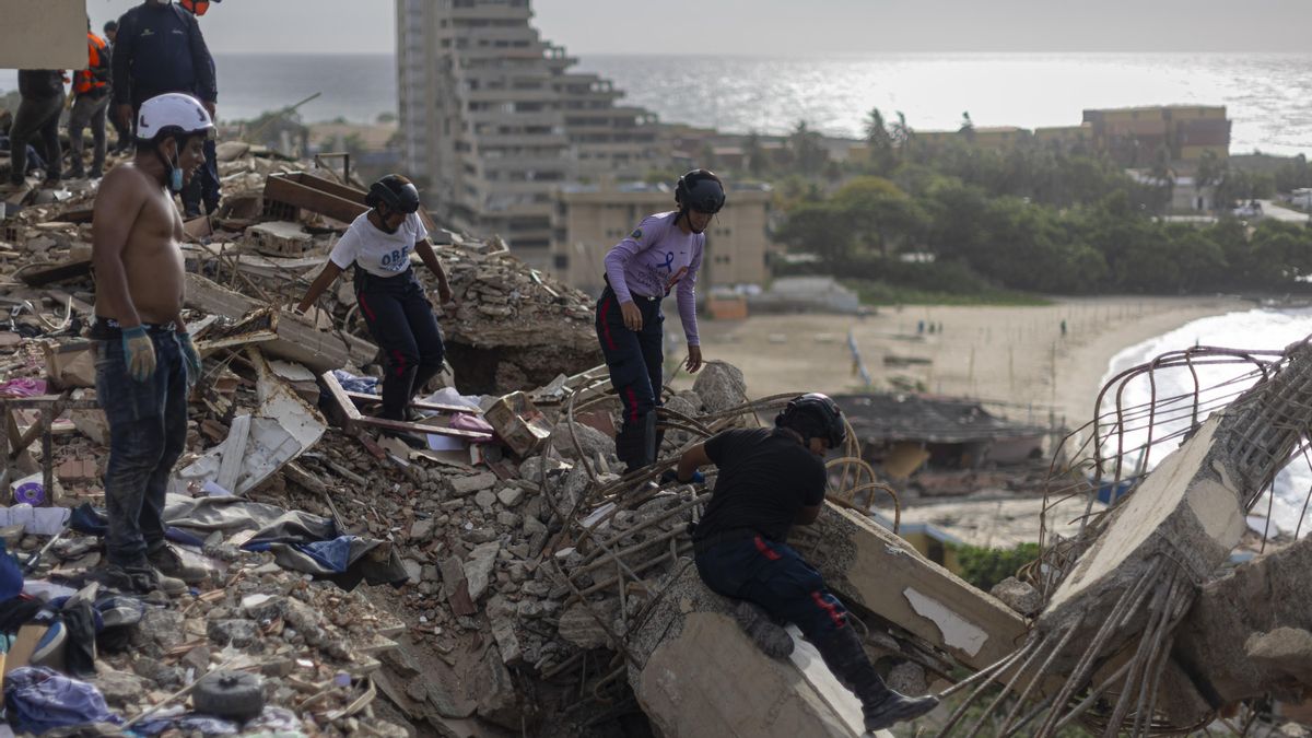 Integrantes de la Protección Civil de Venezuela buscan cuerpos entre los escombros de edificios destruidos.