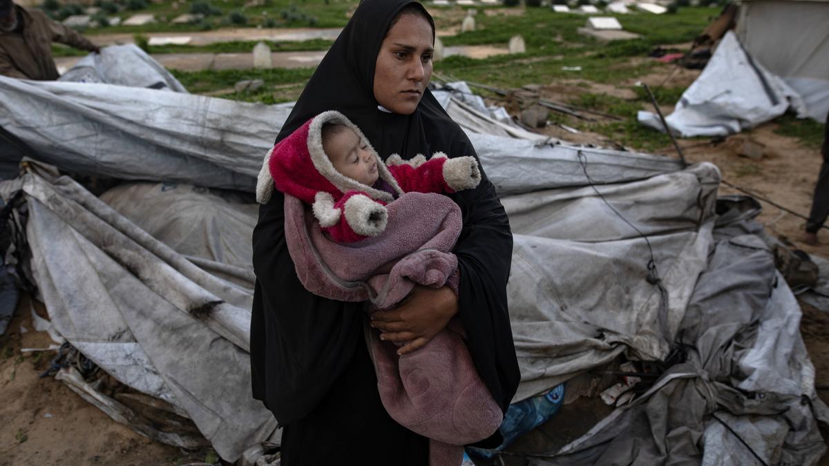 Una mujer palestina lleva a su bebé en Khan Younis, en el sur de la Franja de Gaza.