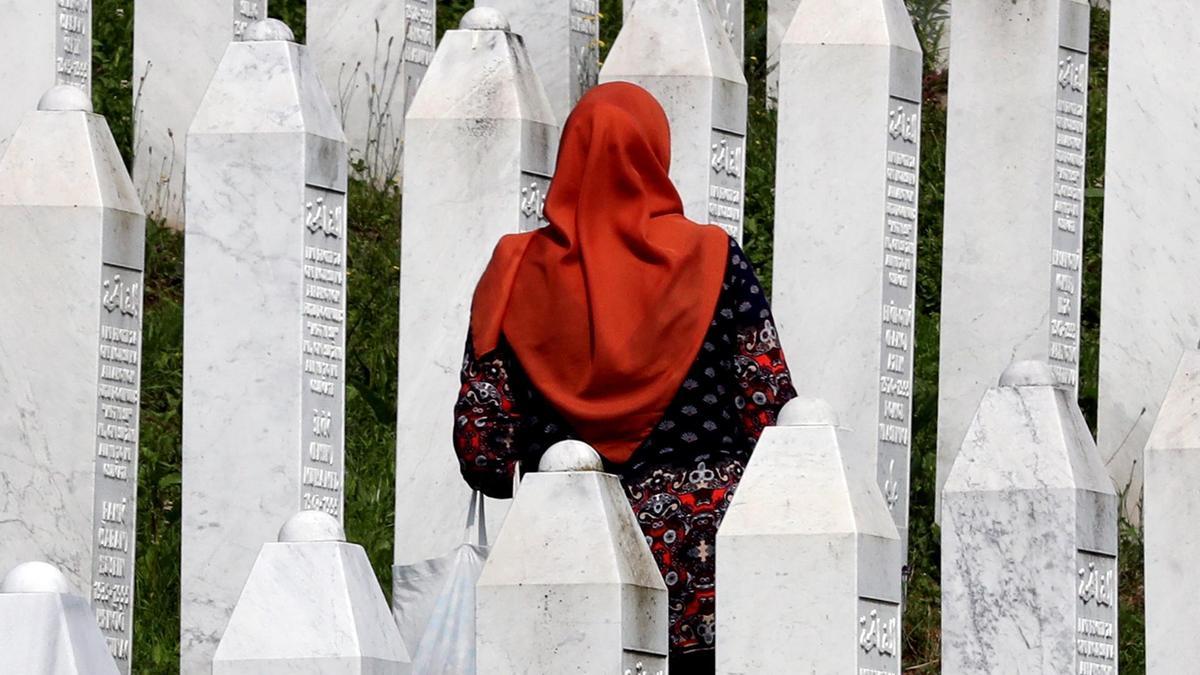 Una mujer bosnia musulmana pasea entre lápidas durante el funeral de 30 bosnios musulmanes identificados como víctimas del genocidio, en el cementerio de Potočari, el 11 de julio de 2023.