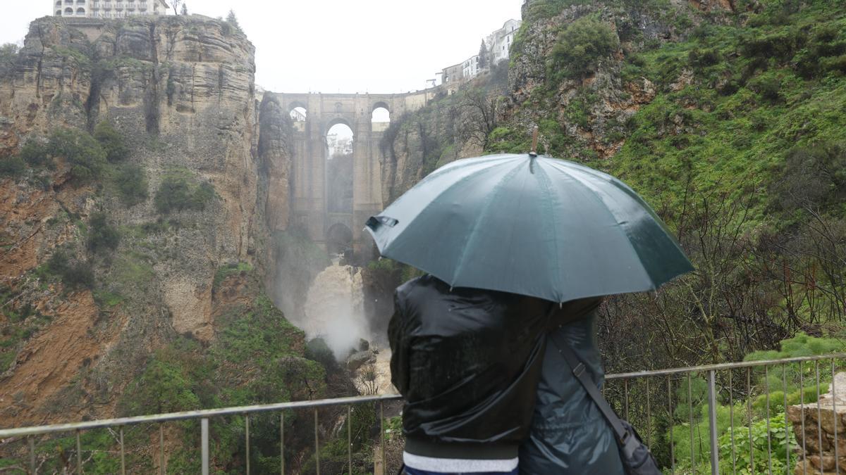 Dos personas miran hacia el puente de la localidad de Ronda (Málaga) durante la borrasca 'Leonardo'.
