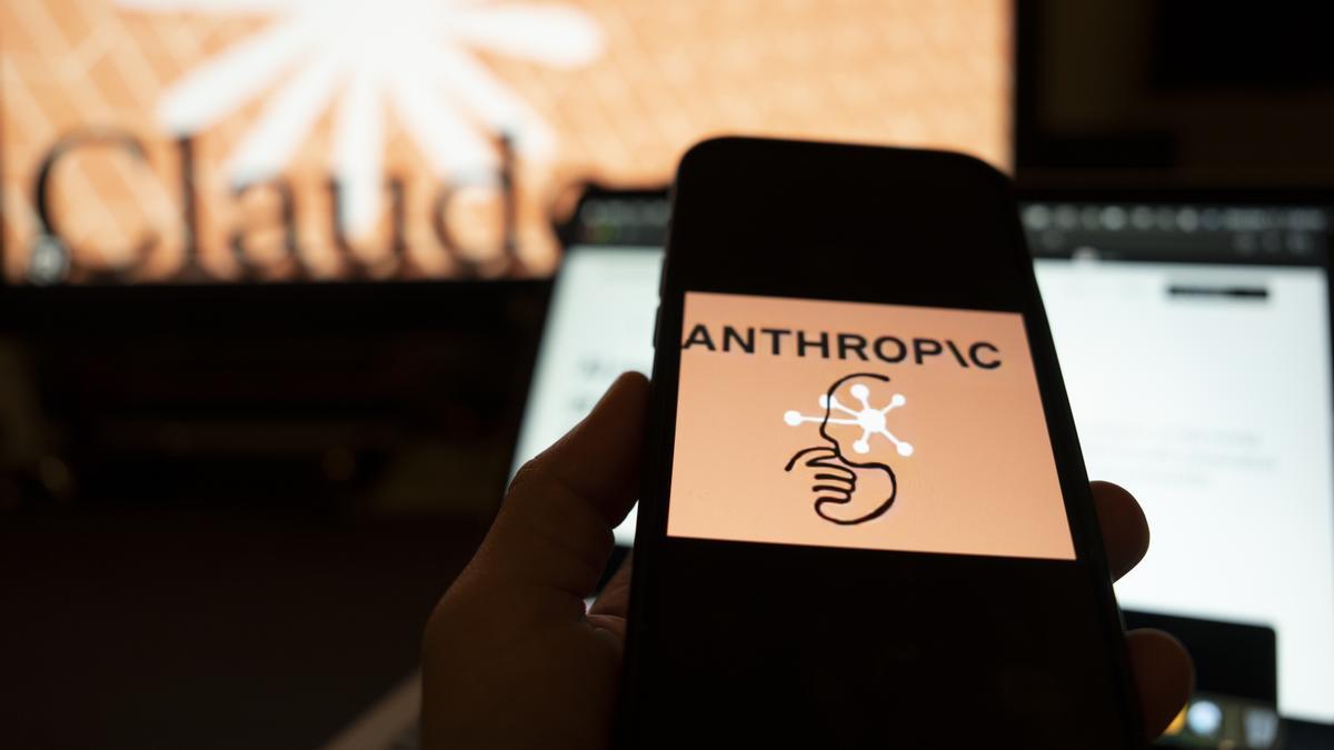 Fotografía de archivo con una persona sosteniendo un teléfono con el logotipo compañía Anthropic.
