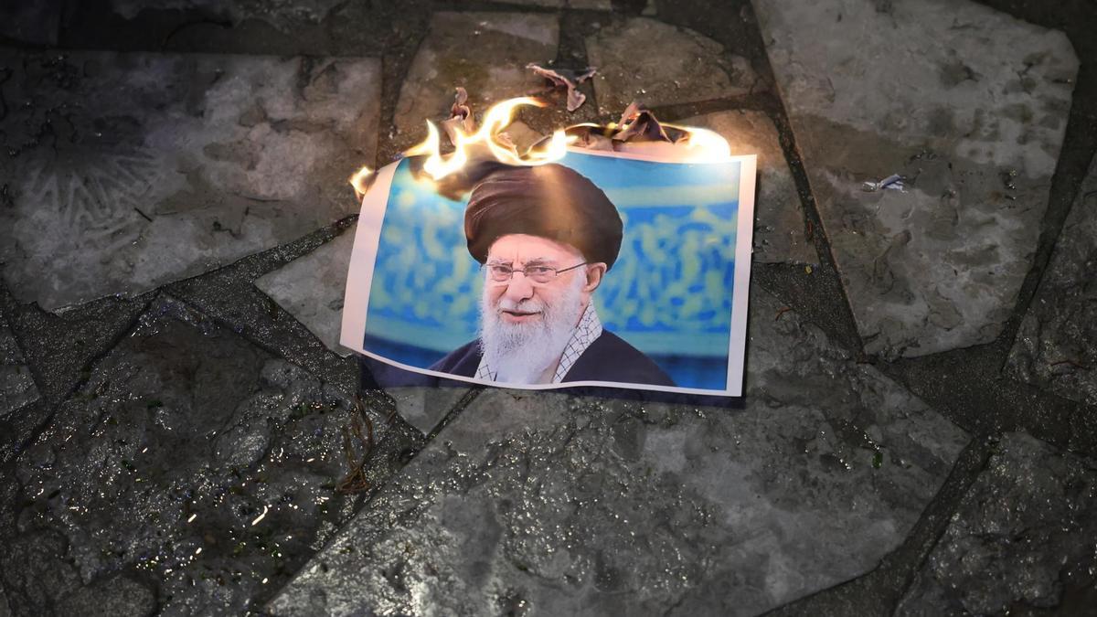Manifestantes queman una imagen del Líder Supremo de Irán, Alí Jamenei, durante una protesta en apoyo al pueblo iraní.